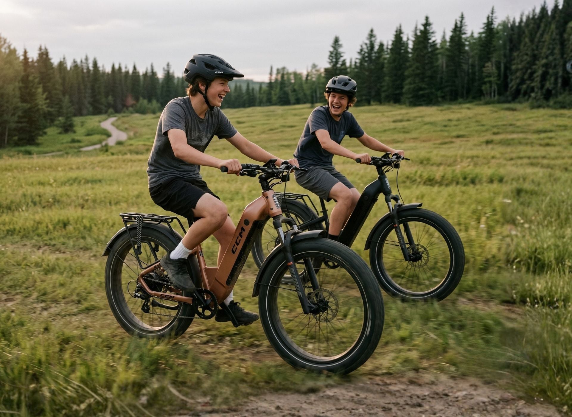 Boys riding through a grass field on CCM Nahanni Step through eBikes All-terrain