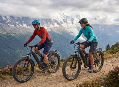 Couple mountain biking on CCM Caribou eBikes All-terrain Fat Tire