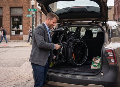 Man storing a CCM Portage folding ebike in his car